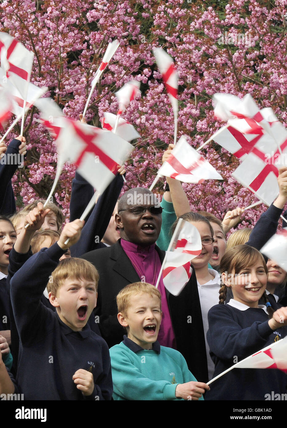 Celebrando il giorno di San Giorgio, l'arcivescovo di York, il Dr. John Sentamu, fa ondere la sua bandiera con i bambini delle scuole locali. Foto Stock