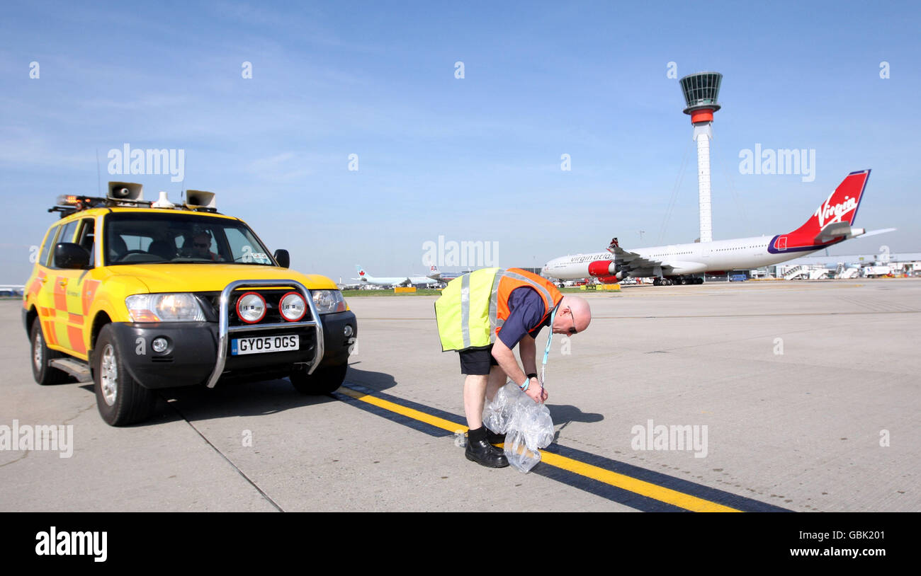 L'unità di sicurezza Airside Operations rimuove i FOD (detriti di oggetti estranei) dal campo d'aviazione dell'aeroporto di Heathrow, Middlesex, come parte delle ispezioni che si svolgono più volte al giorno Foto Stock