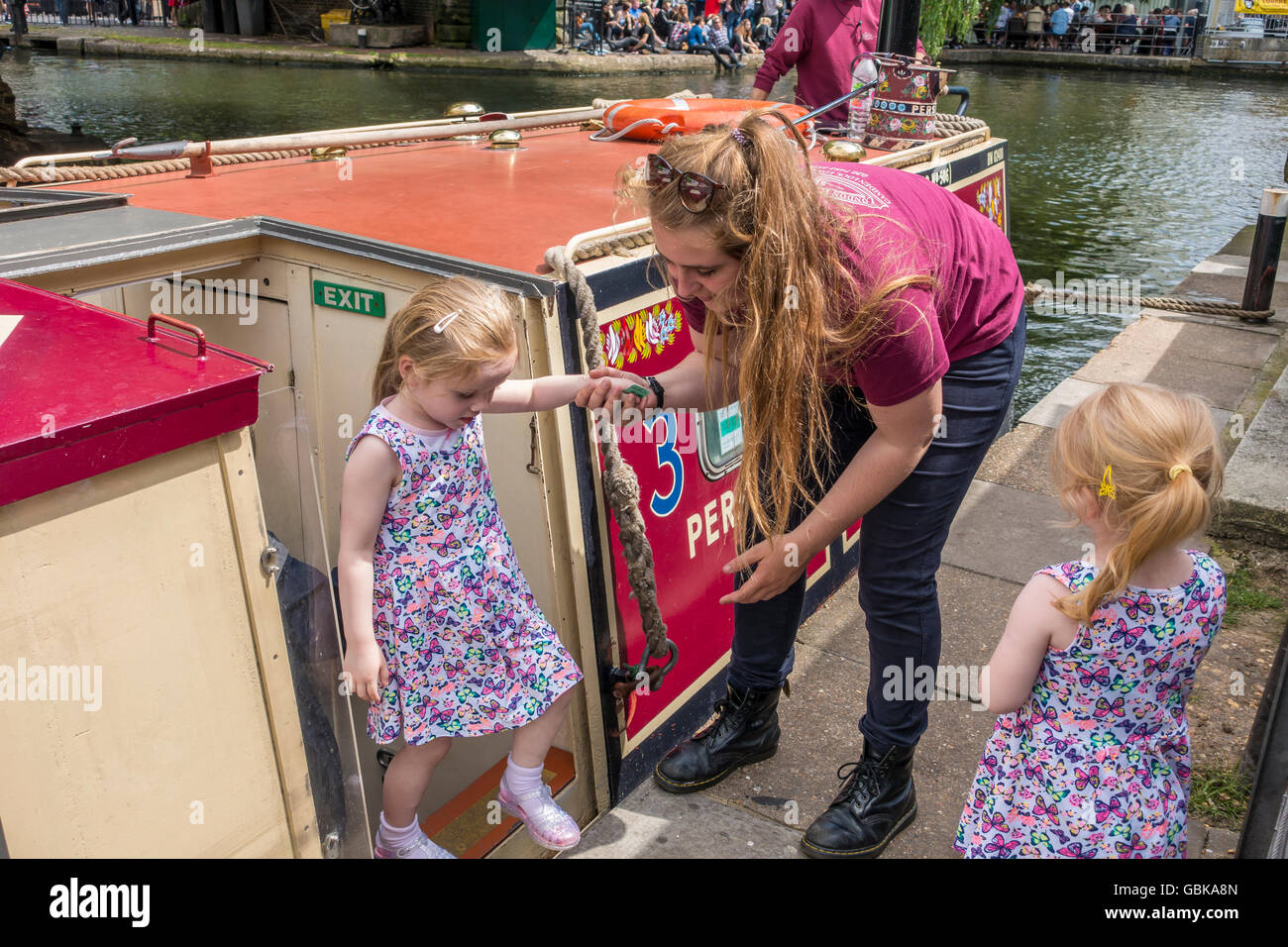 London Waterbus Company membro dello staff aiutando i giovani passeggeri Camden Lock London Foto Stock