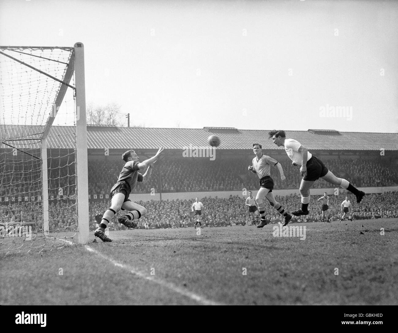 Bobbie Smith (r), di Tottenham, dirige il primo goal della sua squadra oltre il portiere di Wolverhampton Wanderers Malcolm Finlayson (l) al Molineux Ground. Bill Slater, il capitano dei Wolves, è visto secondo da destra. Foto Stock