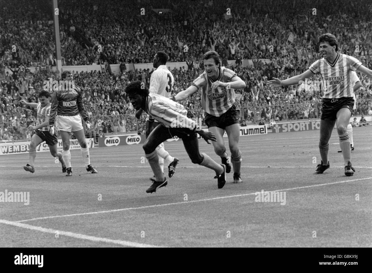 Coventry City's Nick Pickering (r), Keith Houchen (seconda r) e Mickey Gynn (l) si affrettano a congratularmi con il compagno di squadra Dave Bennett (c) dopo aver fatto il punteggio 1-1, come Tottenham Hotspur portiere Ray Clemence (seconda l) gemisce al compagno di squadra Mitchell Thomas (c, dietro Bennett) Foto Stock