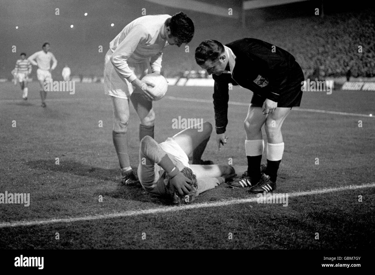 Norman Hunter (l) di Leeds United e l'arbitro controllano le condizioni del portiere Unito Gary Sprake (c) dopo che è stato ferito in una collisione, e infine decollato Foto Stock