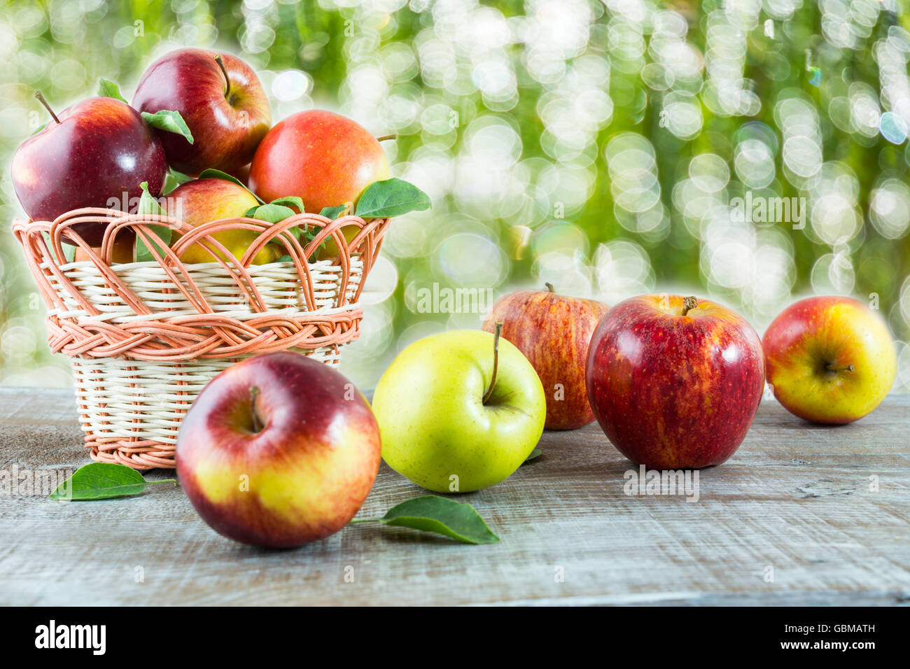 Mele mature sul tavolo di legno nel giardino. Frutta fresca. Mele fresche. Cibo vegetariano. Mangiare sano concetto. Cibo sano Foto Stock