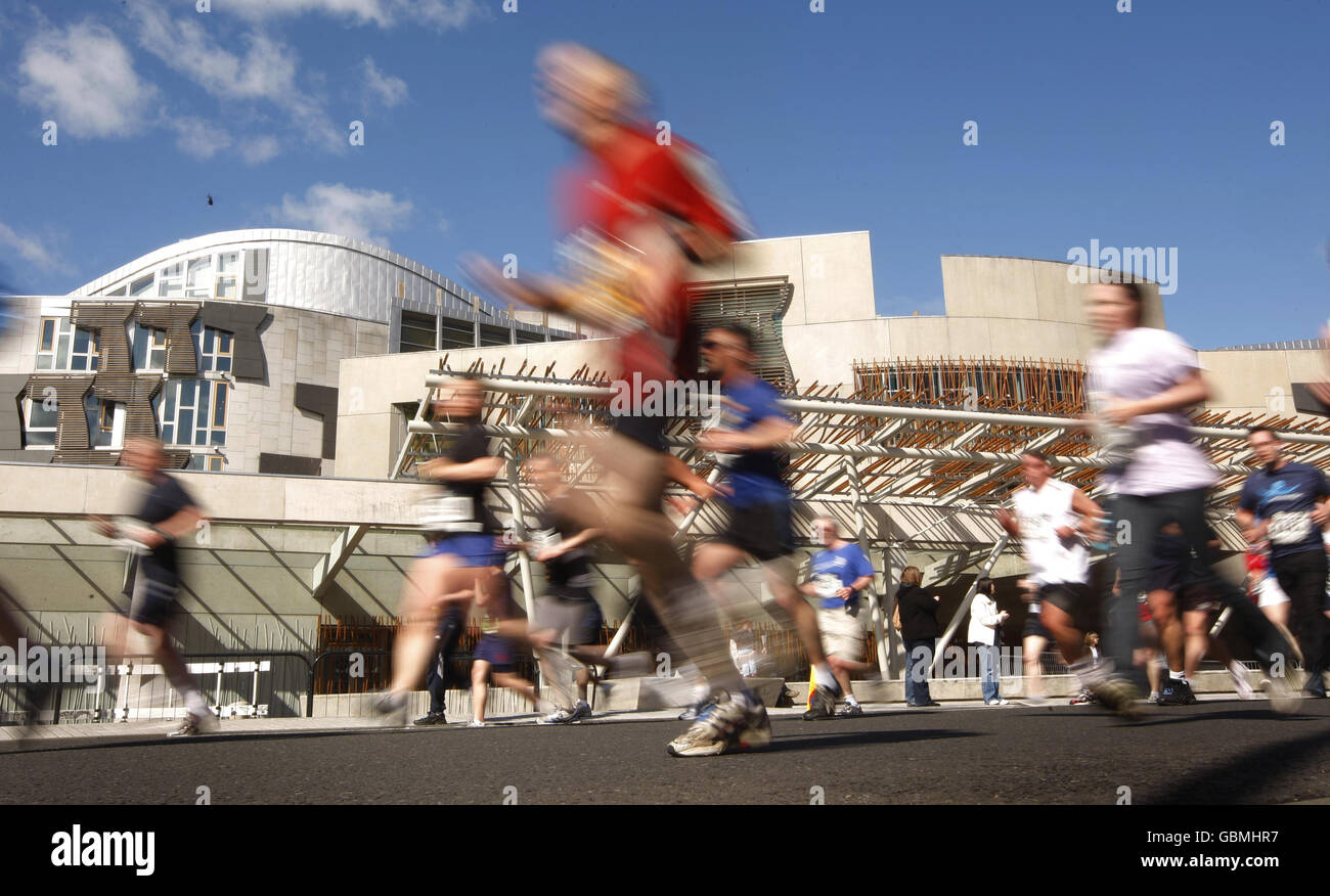 BUPA Great Edinburgh Run. I concorrenti della Bupa Great Edinburgh Run superano il Parlamento scozzese. Foto Stock