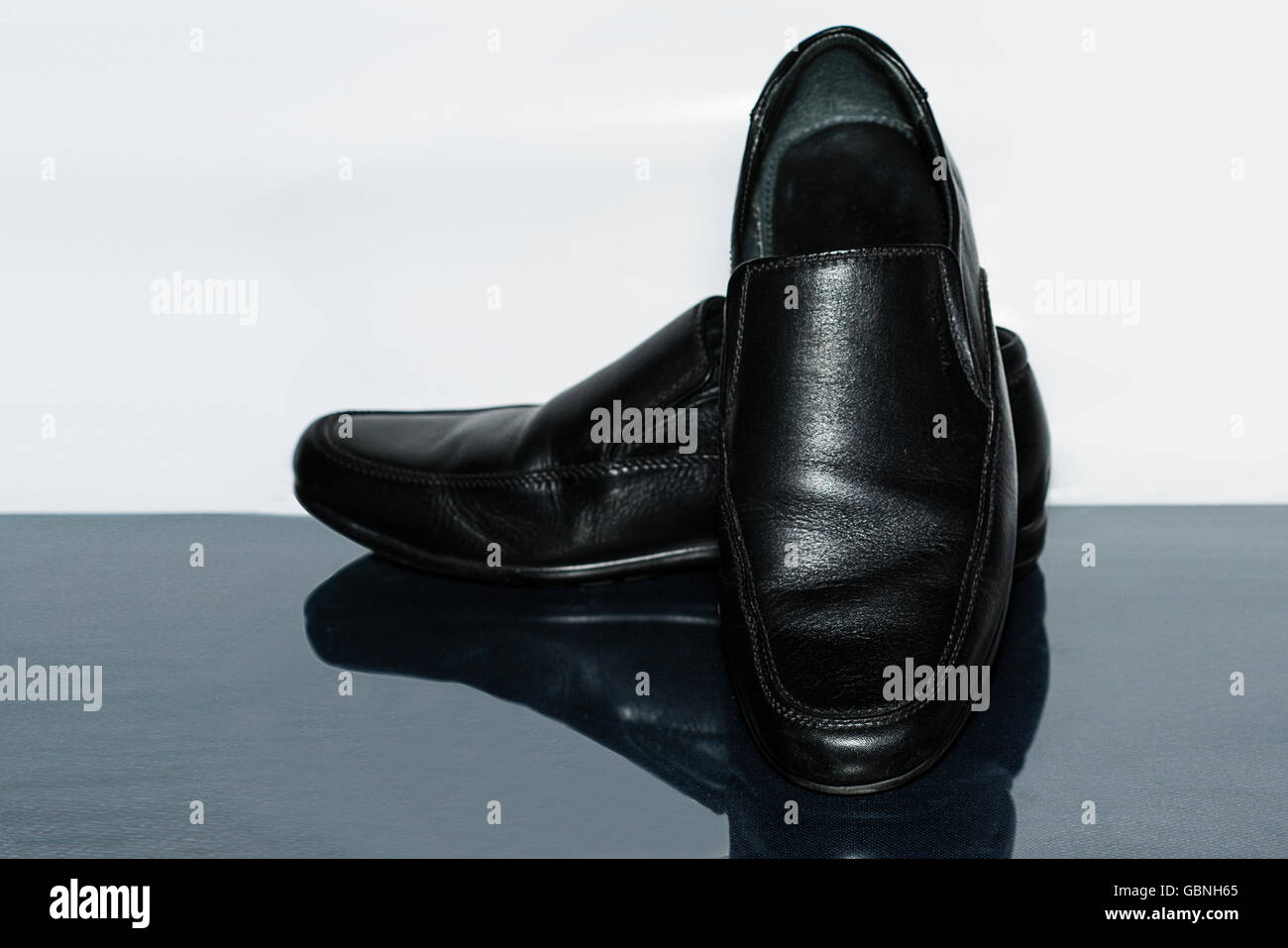 Uomini nero scarpe di cuoio isolato su un bianco e lo sfondo grigio Foto Stock