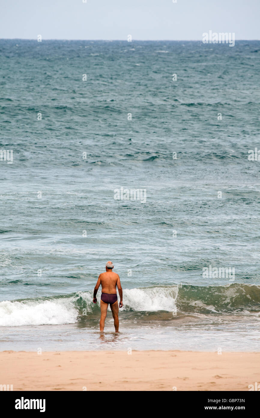 L uomo che sta per andare a nuotare in mare a Comillas Spagna settentrionale Foto Stock