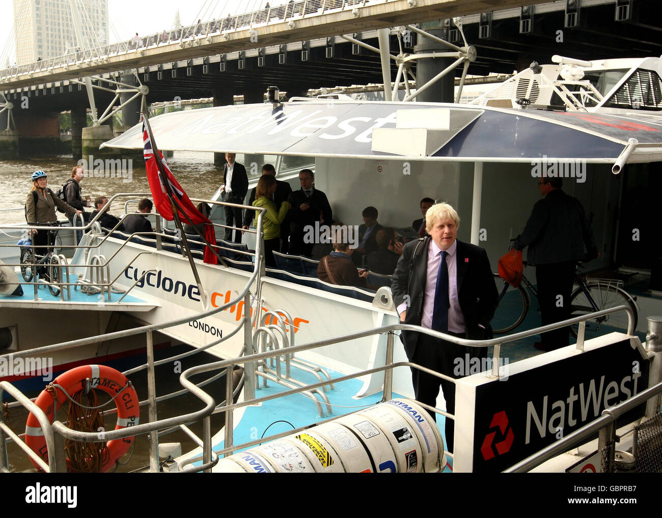 Il sindaco di Londra Boris Johnson e i pendolari salgono a bordo di una barca Thames Clipper, presso il molo Embankment nel centro di Londra, poiché uno sciopero di 48 ore da parte della RMT Union causa un'interruzione diffusa della metropolitana di Londra. Foto Stock