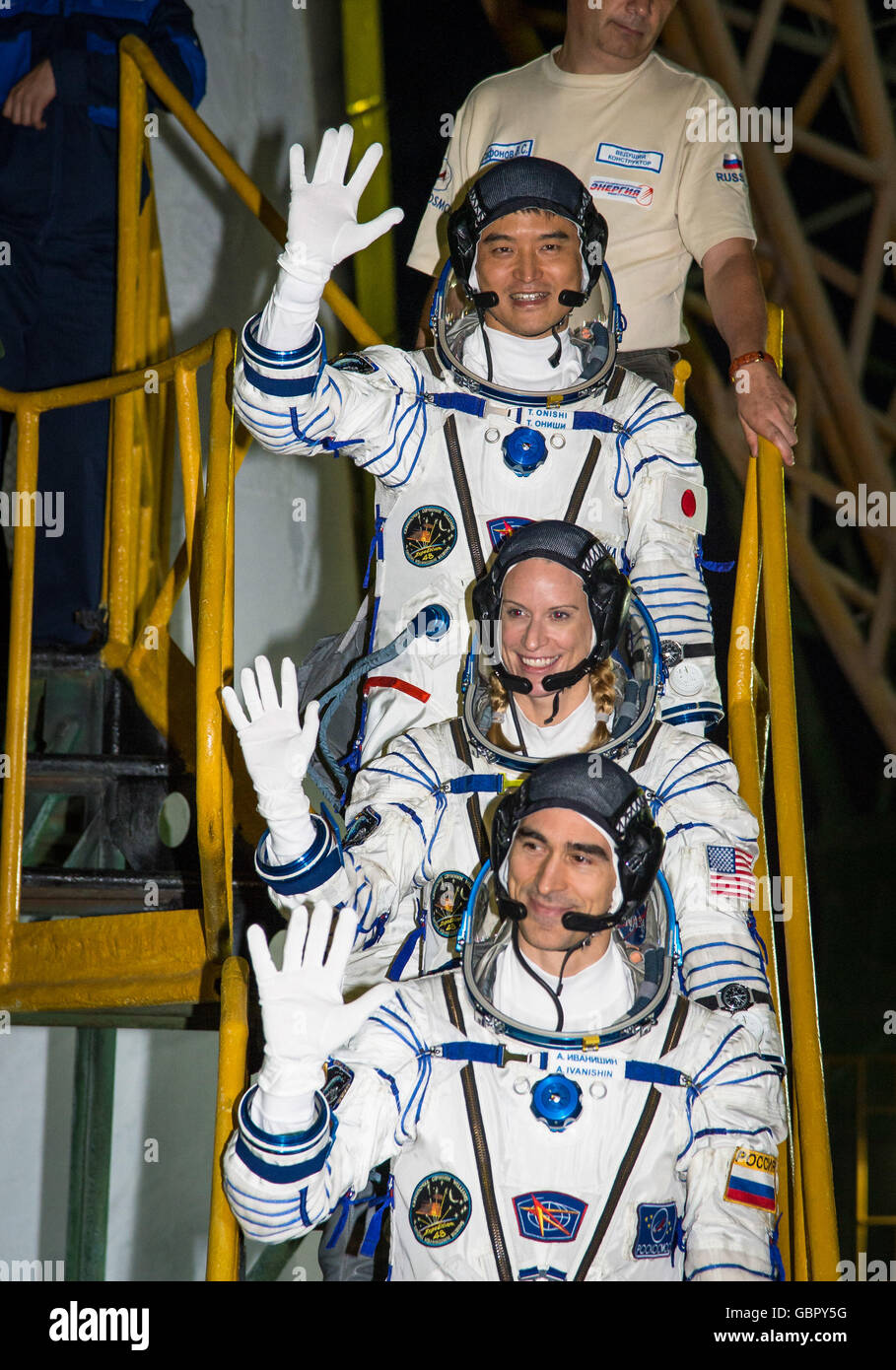 Astronauta giapponese Takuya Onishi, top, astronauta americano Kate Rubins, centro e il cosmonauta russo Anatoly Ivanishin onde come essi bordo della Soyuz MS-01 navicella spaziale per il lancio per la Stazione Spaziale Internazionale presso il cosmodromo di Baikonur Luglio 7, 2016 in Kazakistan. Foto Stock