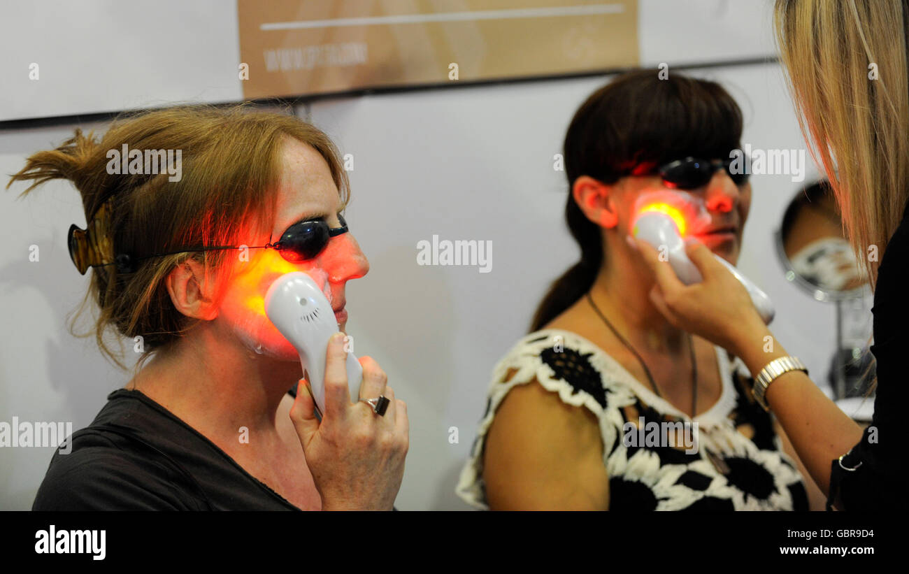 Londra, Regno Unito. 8 luglio 2016. Le donne il test di un dispositivo per la dermocosmesi che utilizza luce a LED e onde di ultrasuoni come migliaia di visitatori a partecipare alla giornata di apertura di una vita sana show all'Olympia di Kensington. La manifestazione prevede l'Allergia + gratis da mostrare, appena V mostra e Amore amore naturale si mostra con oltre 450 espositori che mostra di libero da prodotti alimentari, vegetariane e vegane impianto basato prodotti così come i prodotti di bellezza naturali.. Credito: Stephen Chung / Alamy Live News Foto Stock