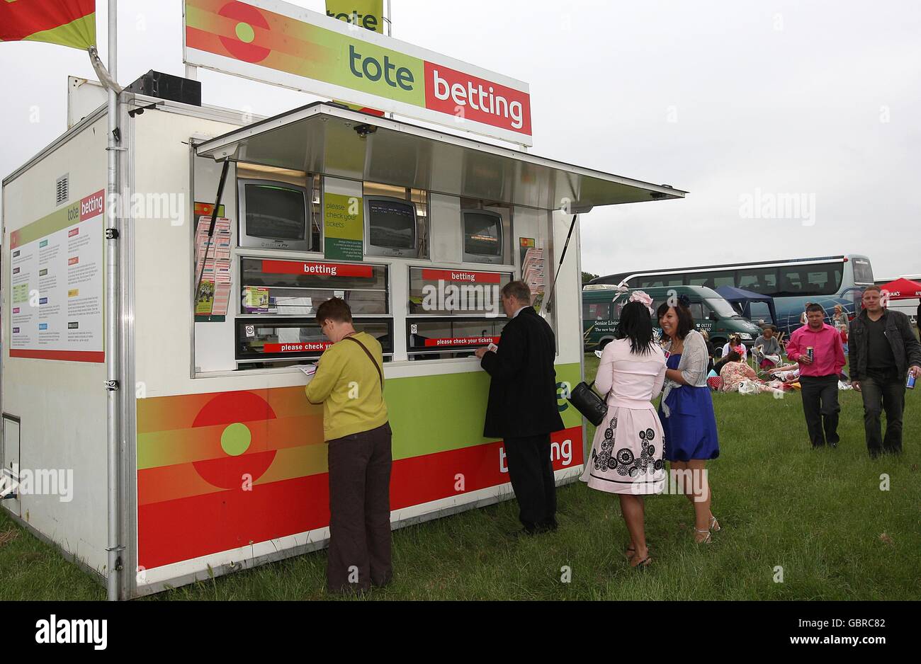 I Racegoers piazzano le loro scommesse presso una stazione di scommesse Tote, durante il Ladies Day all'ippodromo di Epsom Downs. Foto Stock