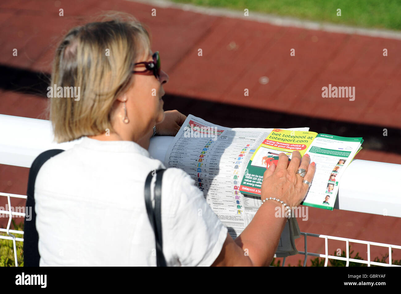 Un racegoista raccoglie i suoi cavalli prima delle corse della giornata, durante l'Irish Day al Sandown Park. Foto Stock