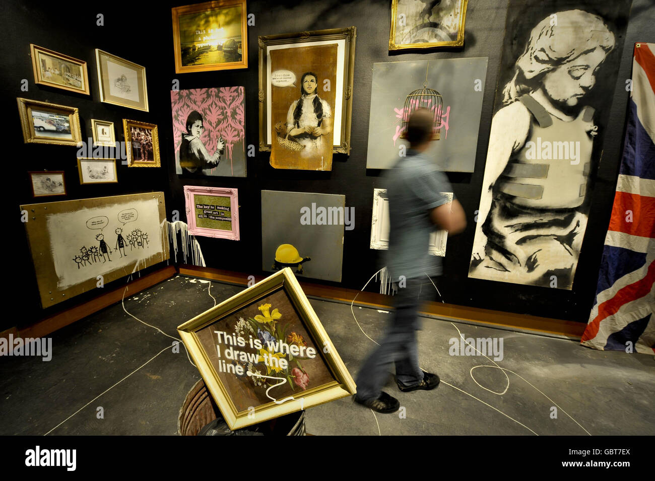 Un uomo ammira le opere d'arte di una mostra dell'artista Banksy al Bristol Museum. Foto Stock