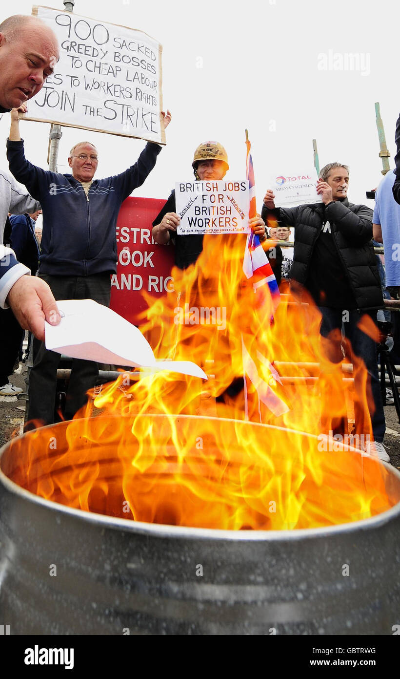 I lavoratori edili bruciano i loro avvisi di licenziamento al di fuori della raffineria Lindsey Oil Refinery in un atto di sfida contro il gigante petrolifero francese Total. Foto Stock