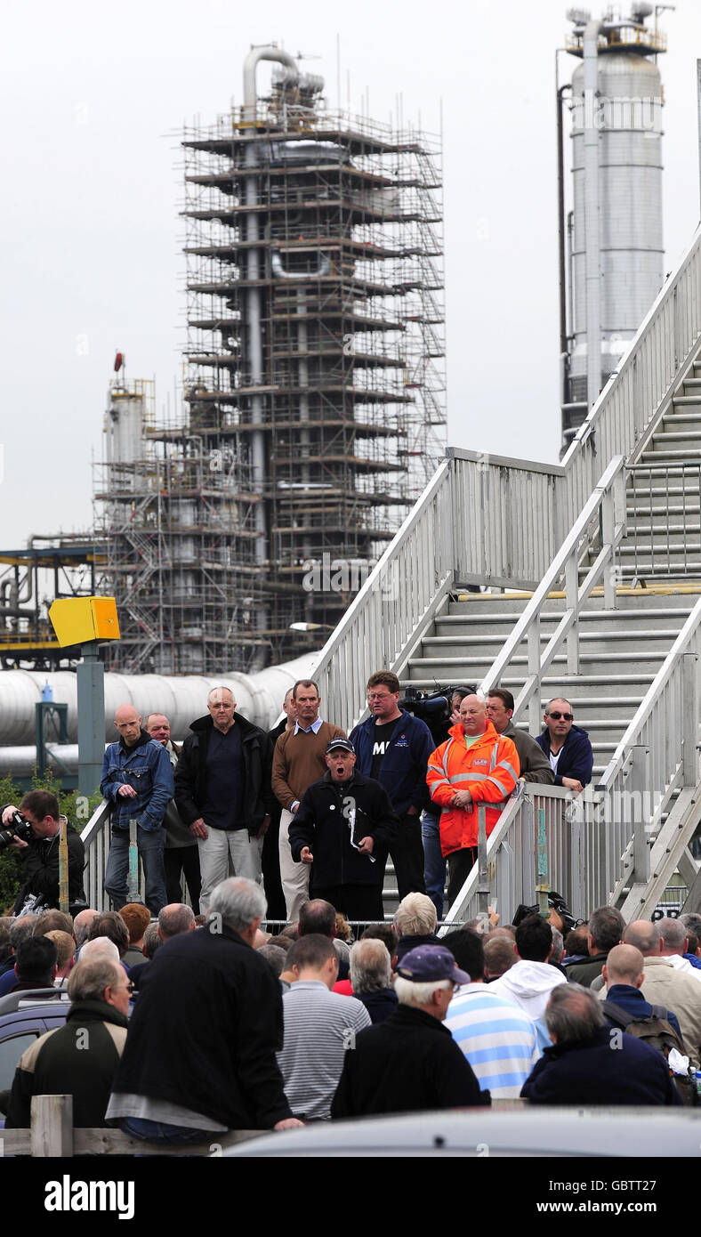 I lavoratori edili ascoltano i loro funzionari e portavoce, poiché alcuni hanno bruciato i loro avvisi di licenziamento al di fuori della raffineria di Lindsey in un atto di sfida contro il gigante petrolifero francese Total. Foto Stock