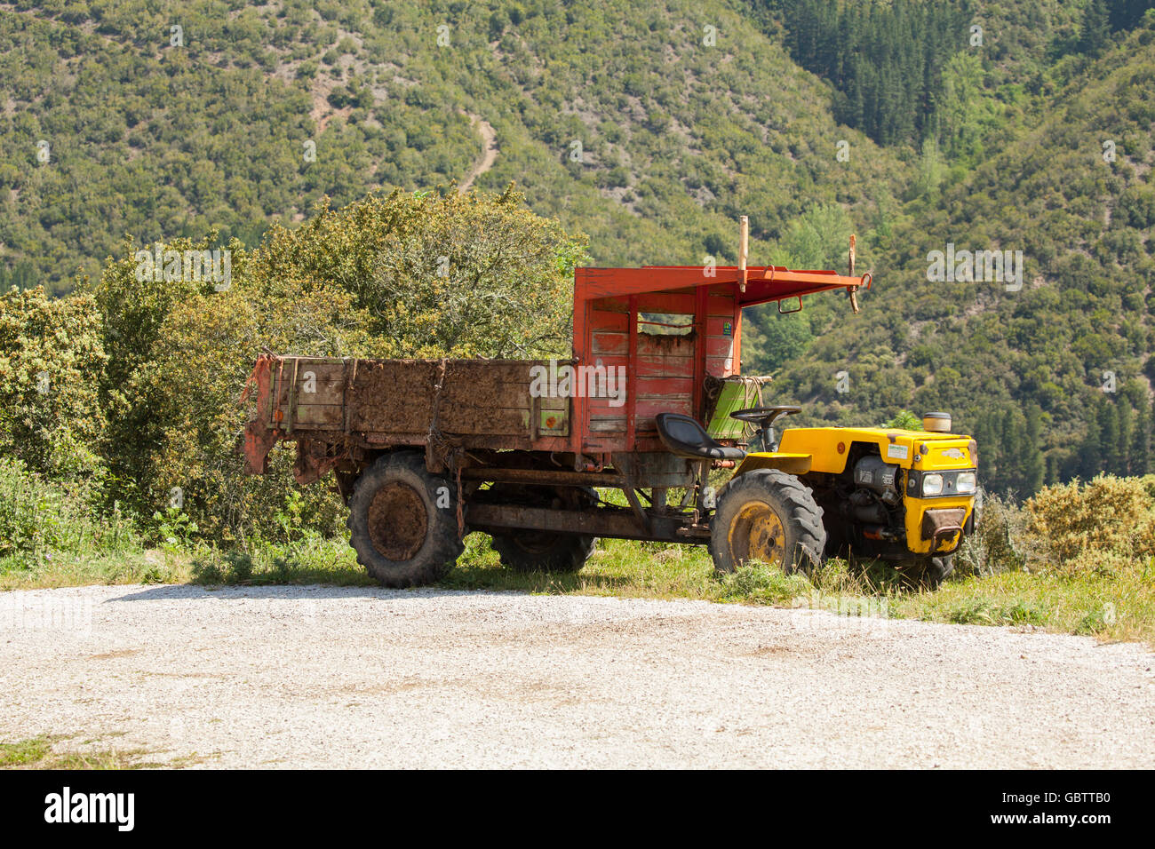 Piccolo trattore e rimorchio nelle colline di Picos de Eurpoa Spagna settentrionale Foto Stock
