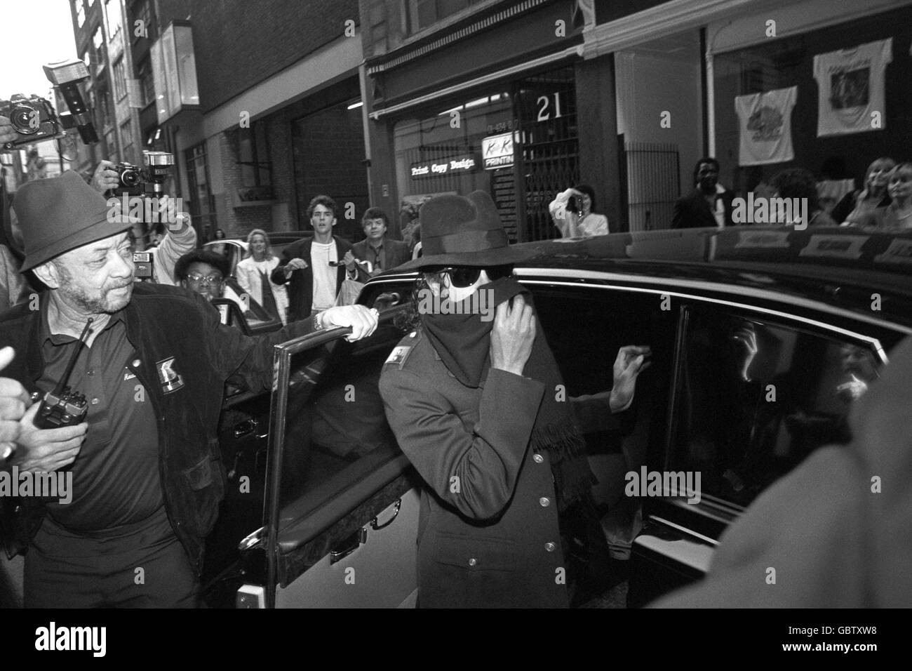 La star pop Michael Jackson ricopre il viso con una sciarpa mentre lascia la sua limousine nera per fare shopping nel negozio di giocattoli di Hamley a Regent Street. Foto Stock