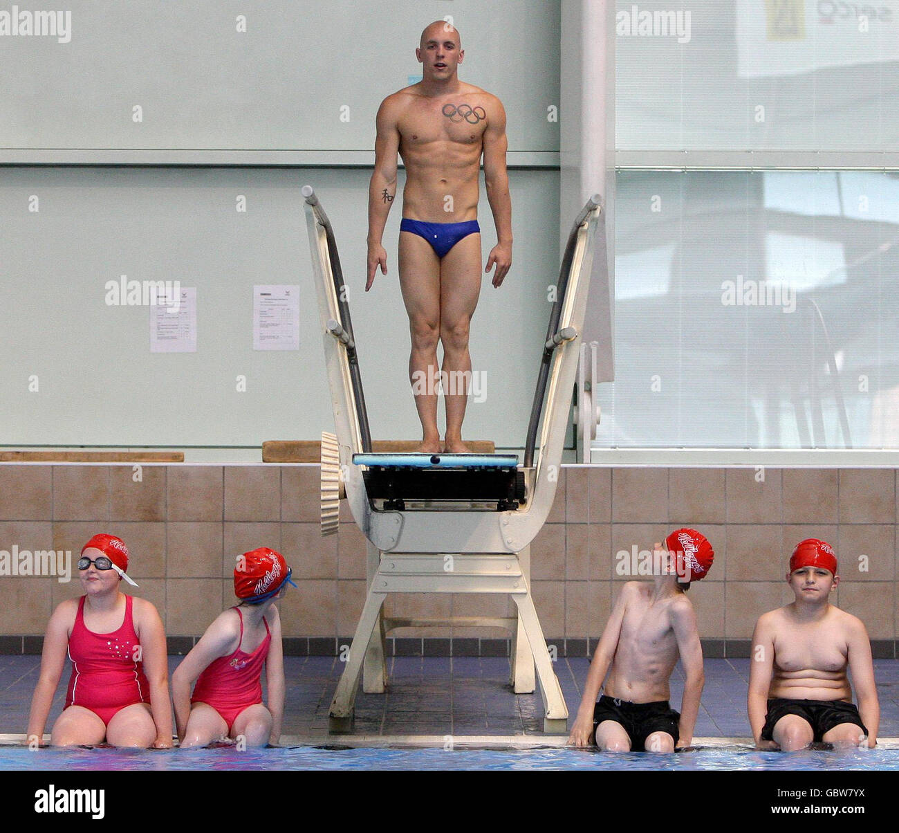 Tre volte la fina World Diving Series Medalista Nick Robinson Baker dà una masterclass diving a (sinistra-destra) Beth Lee, Abbi Jade Reid, Thomas Reid e Ethan Bennett della BroakOak School al Manchester Aquatic Center, Manchester. Foto Stock