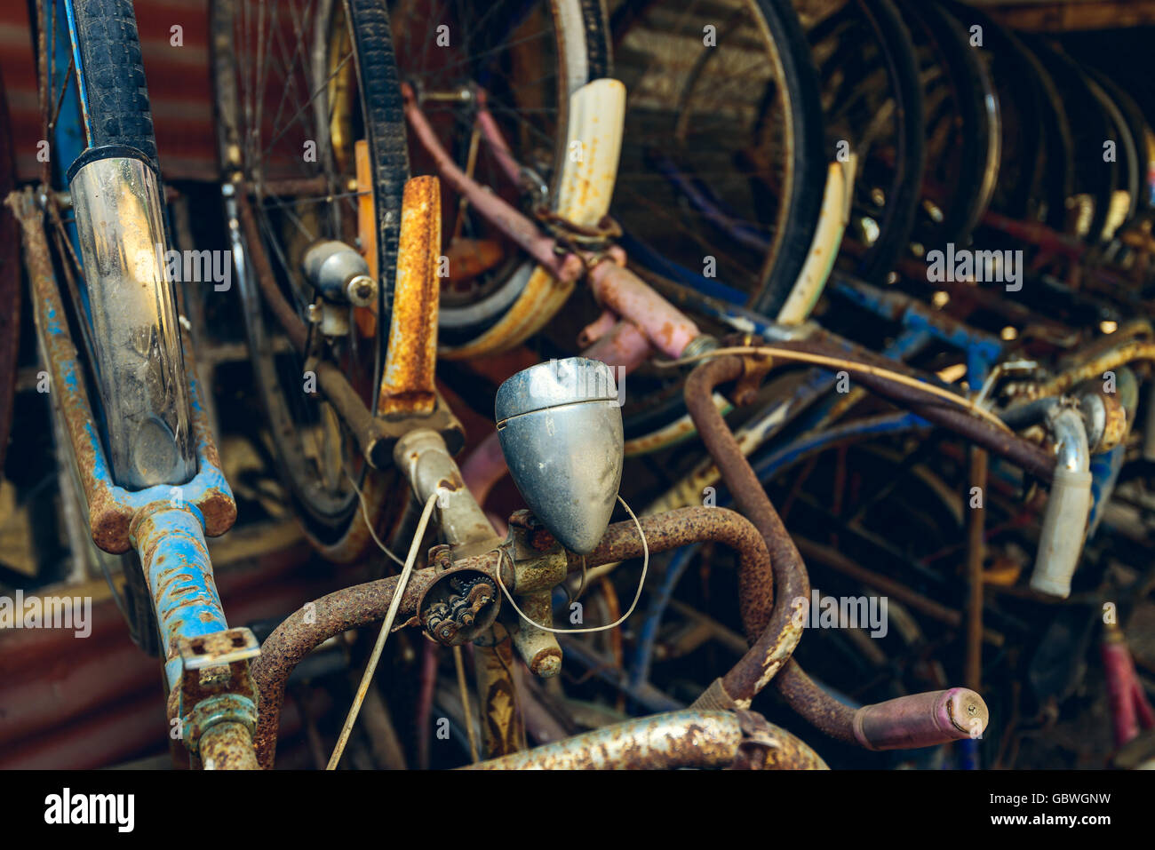 Vecchio arrugginito biciclette stack in una pila nel capannone. Color-tonificante applicato Foto Stock