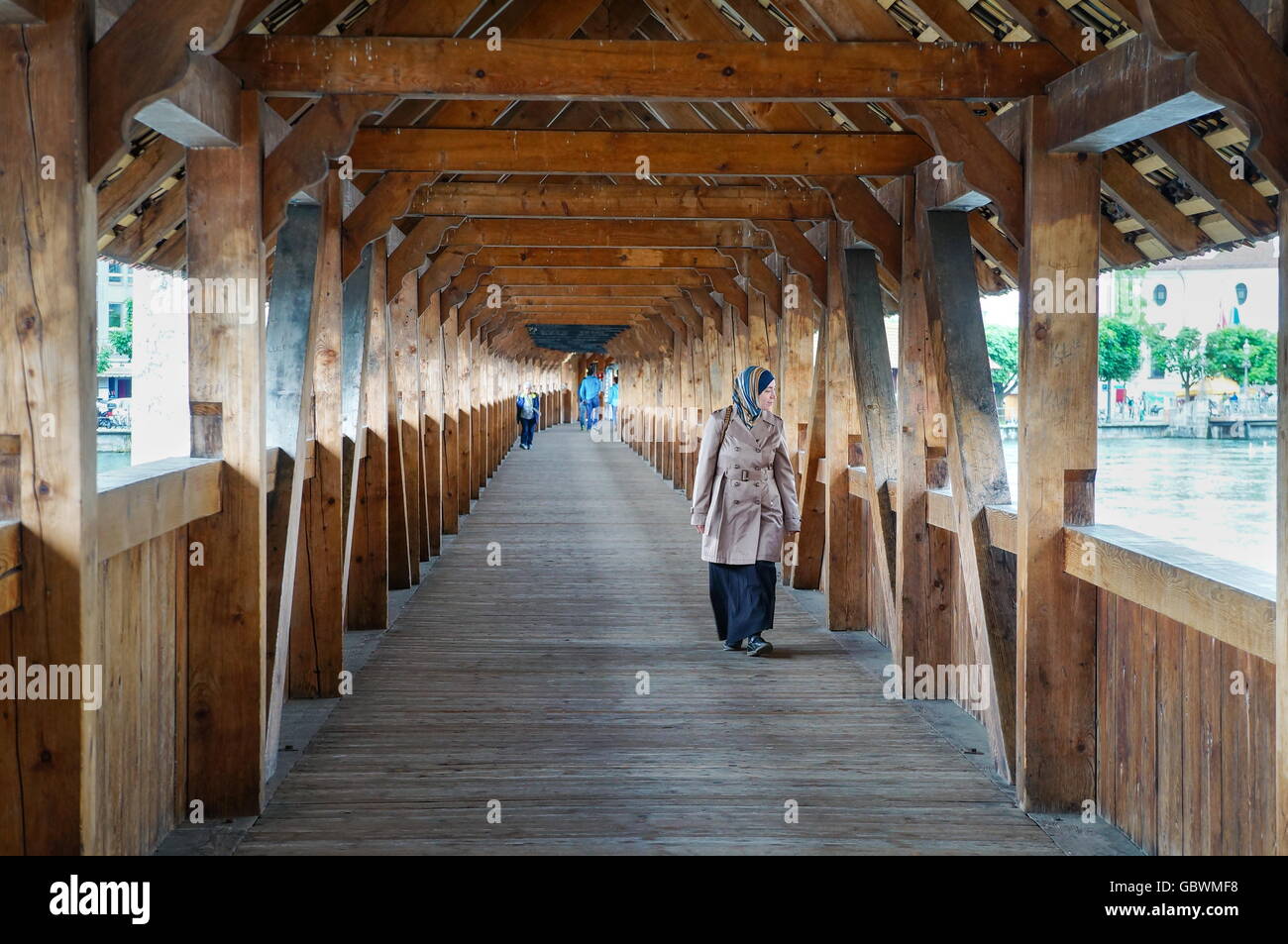 Lucerna, Svizzera - 13 giugno 2016: donna non identificato transitando in legno ponte famoso in Lucerna durante il giorno Foto Stock