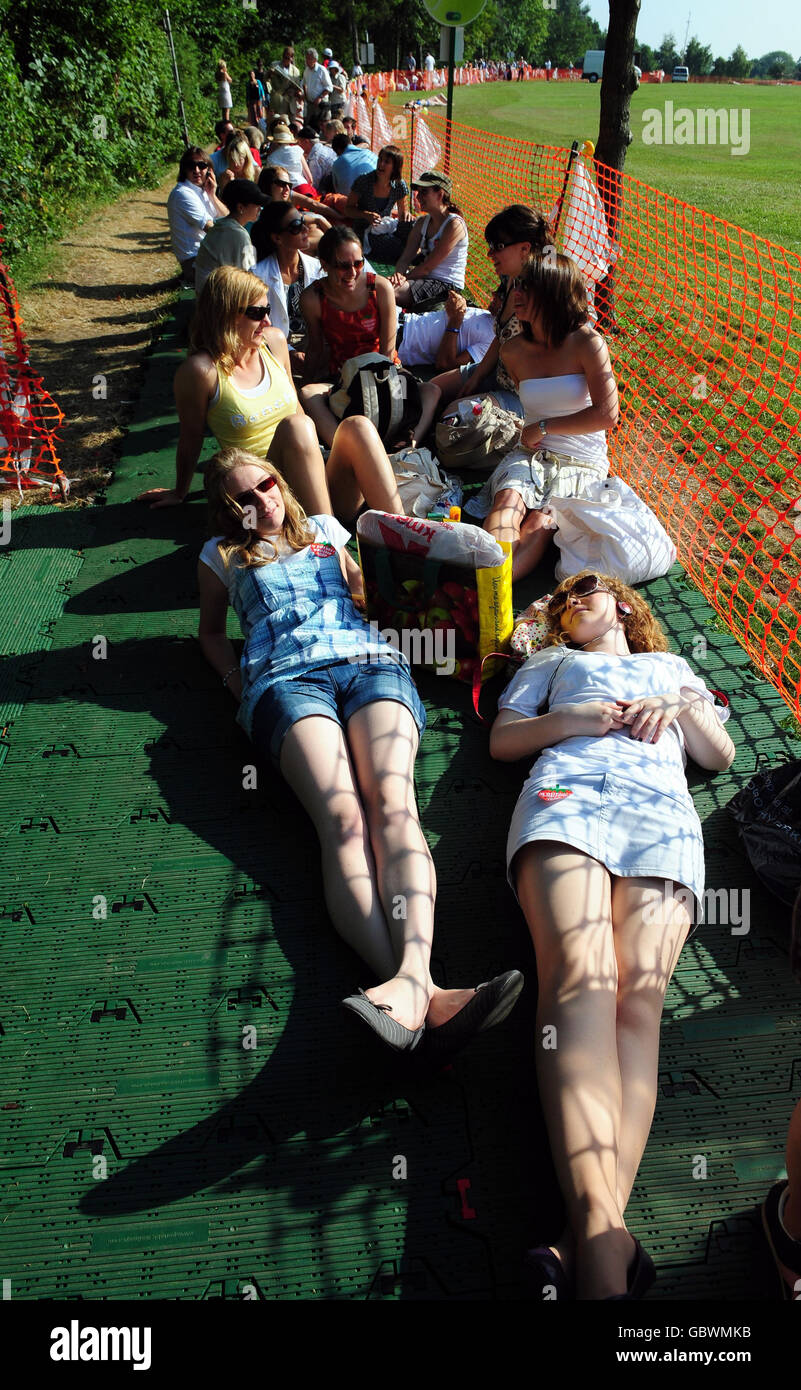 Gli appassionati di tennis potranno prendere il sole mentre si accodano durante i Campionati di Wimbledon all'All England Lawn Tennis and Croquet Club, Wimbledon, Londra. Foto Stock