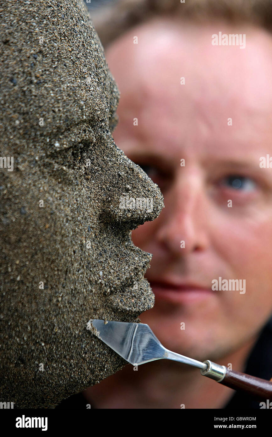 L'artista Daniel Doyle mette i tocchi di finitura alla sua scultura di sabbia a grandezza naturale utilizzando due tonalità di sabbia. La scultura illustra l'impatto umano del cambiamento climatico durante il lancio di Oxfam Irlanda delle vite di Climate Change Destroy - Let Face IT a Dublino. Foto Stock