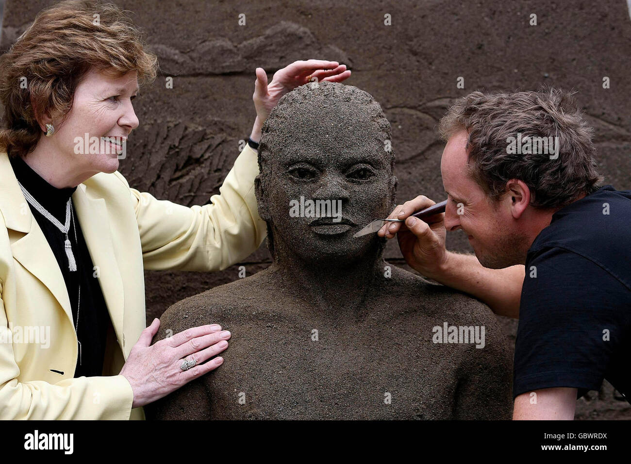 L'artista Daniel Doyle e il presidente onorario Oxfam Mary Robinson, hanno messo i tocchi di finitura alla sua scultura di sabbia a grandezza naturale utilizzando due tonalità di sabbia. La scultura illustra l'impatto umano del cambiamento climatico durante il lancio di Oxfam Irlanda delle vite di Climate Change Destroy - Let Face IT a Dublino. Foto Stock
