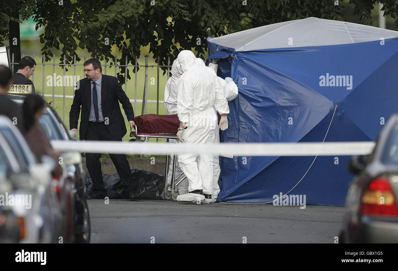 L'uomo ha sparato morto. Il corpo di un uomo nei suoi venti è rimosso dalla scena dove è stato ucciso a colpi di arma da fuoco a Ballyfermot, Co Dublino. Foto Stock