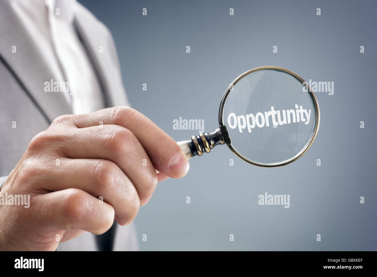 Imprenditore con lente di ingrandimento alla ricerca di opportunità Foto Stock