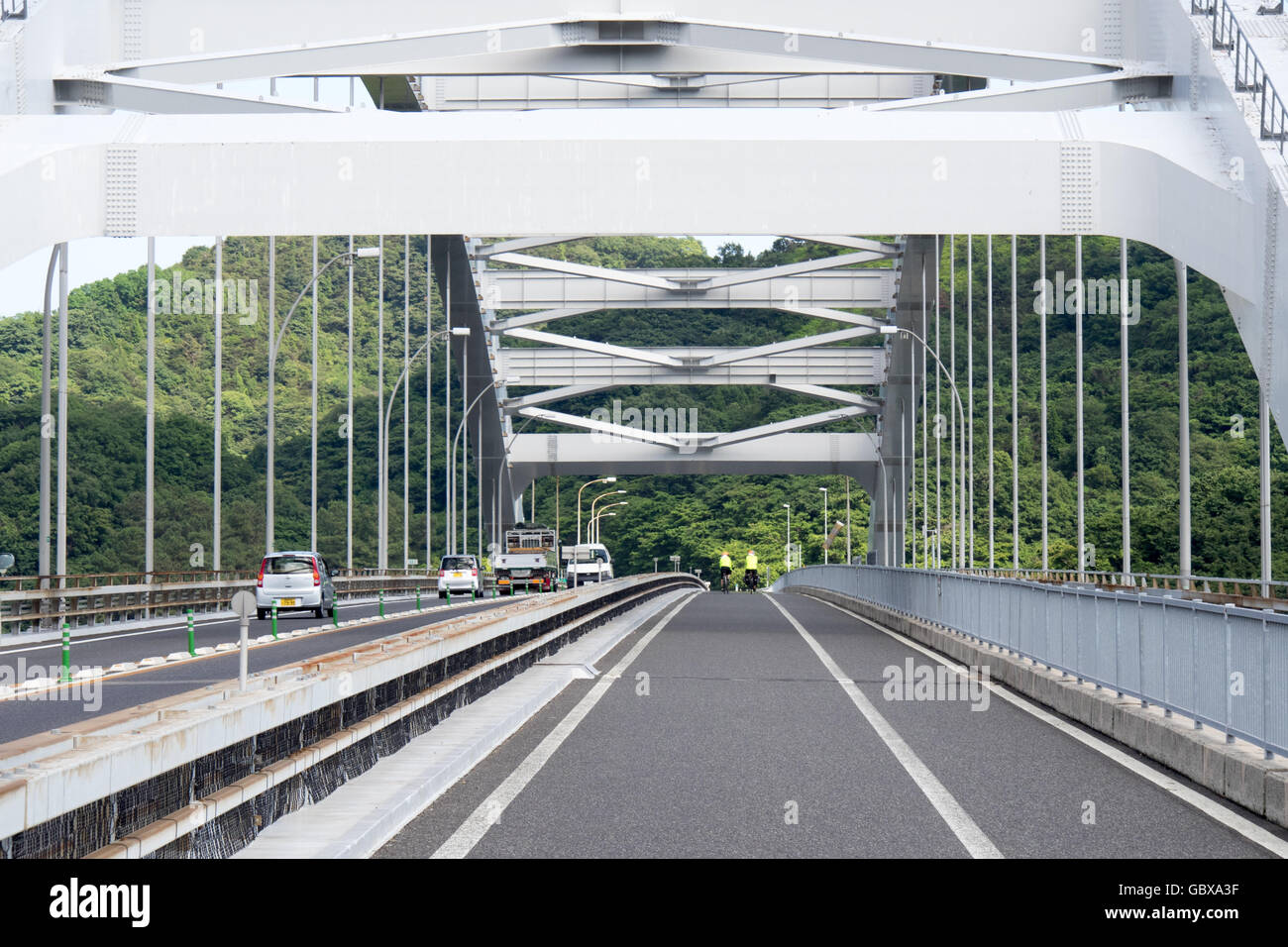 Due ciclisti che attraversano la Omishima ponte di collegamento tra le isole di Omishima e Hakata nella Seto Inland Sea. Foto Stock