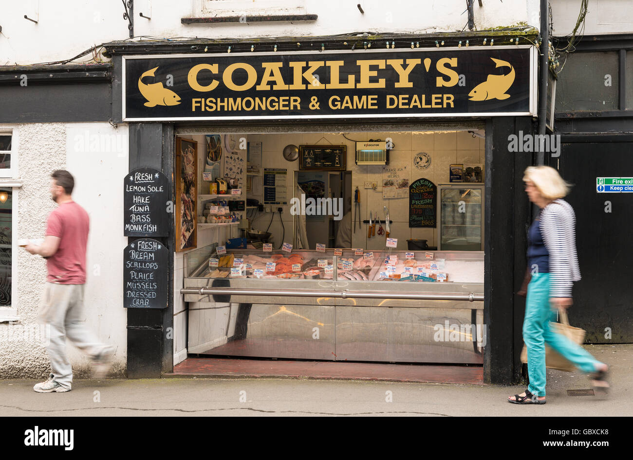 Gli amanti dello shopping comprare pesci a Coakleys pescivendolo, Mumbles, Swansea, Wales, Regno Unito Foto Stock