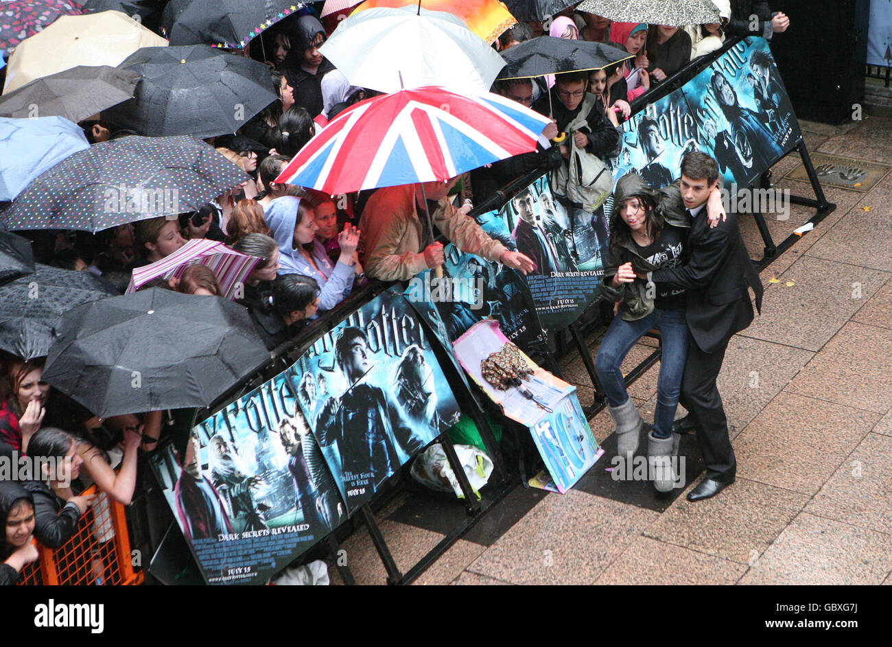 Un fan è rimosso dalla folla durante la pioggia pesante alla prima mondiale di Harry Potter e il Principe Mezzosangue all'Odeon Leicester Square, Londra. Foto Stock