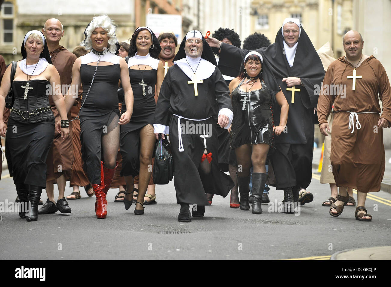 Un gruppo di amici di Bristol ed Exeter cammina lungo Small Street a Bristol vestita da frati e monache in un giro dei pub in città per celebrare due delle feste di compleanno congiunte. Foto Stock