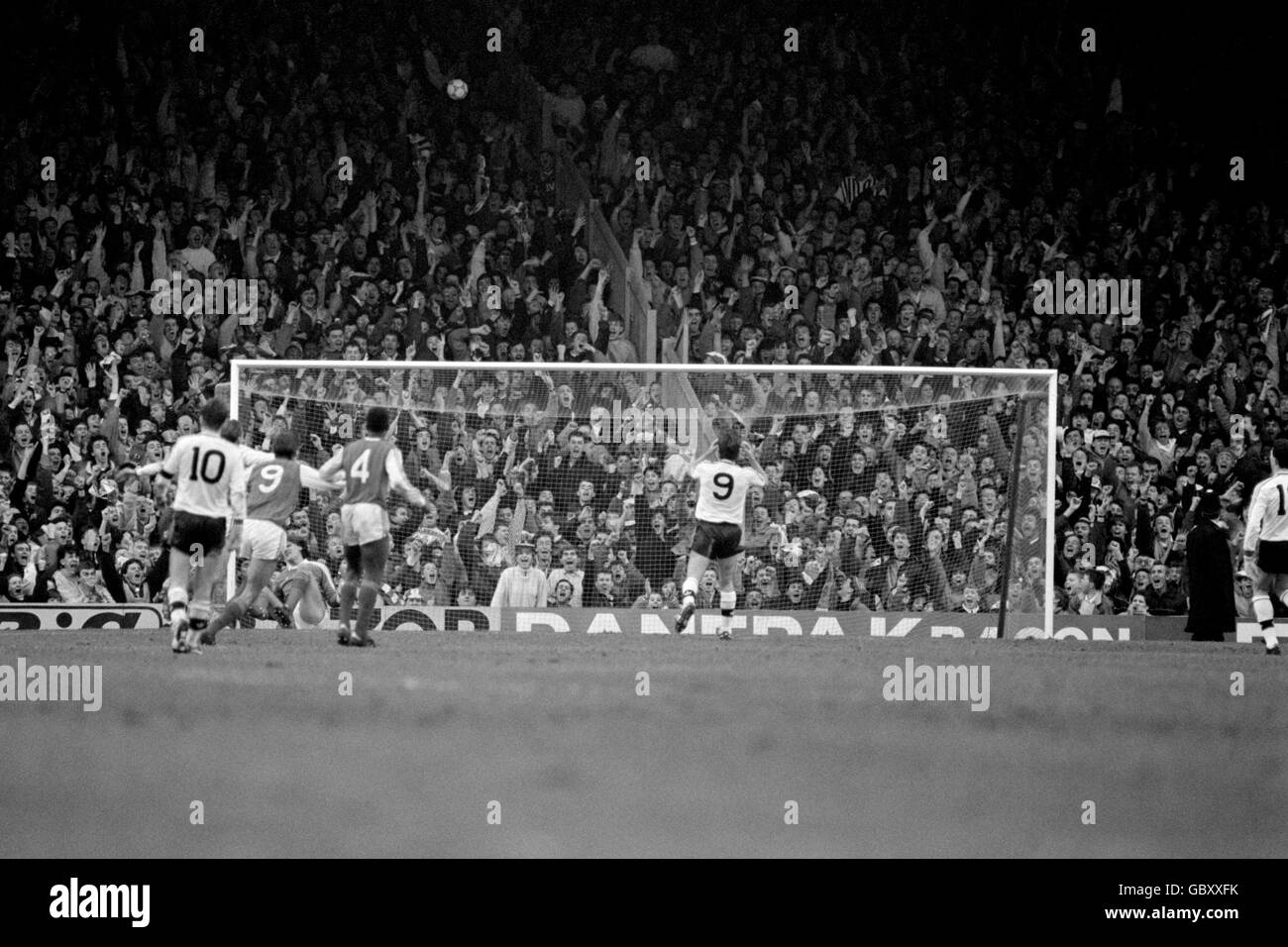 Brian McClair (9) del Manchester United tiene la testa in deiezione dopo aver scolpato una pena sopra il bar, mentre i fan dell'Arsenal dietro l'obiettivo celebrano Foto Stock