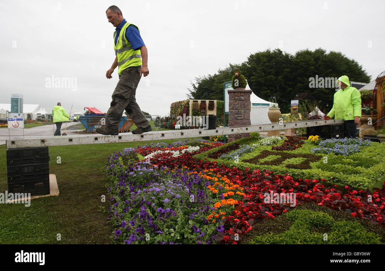 Un espositore tende alla sua esposizione al RHS Show di Tatton Park, Cheshire. Lo spettacolo inizia domani e si svolge fino al 26 luglio. Foto Stock