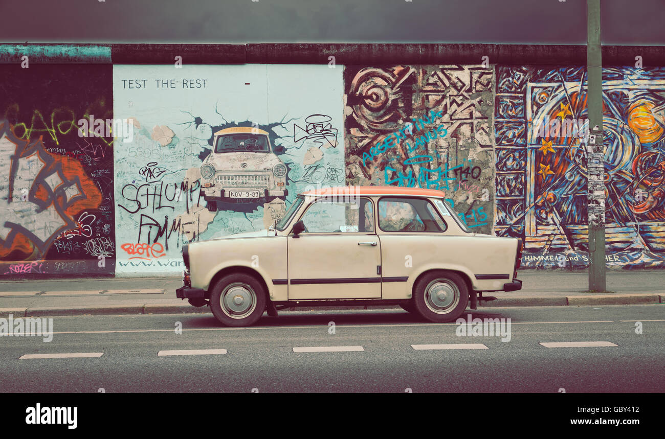 Famosa Berliner Mauer (Berlino) Parete a East Side Gallery con una vecchia Trabant, il più comune veicolo utilizzato nella Germania orientale, in f Foto Stock