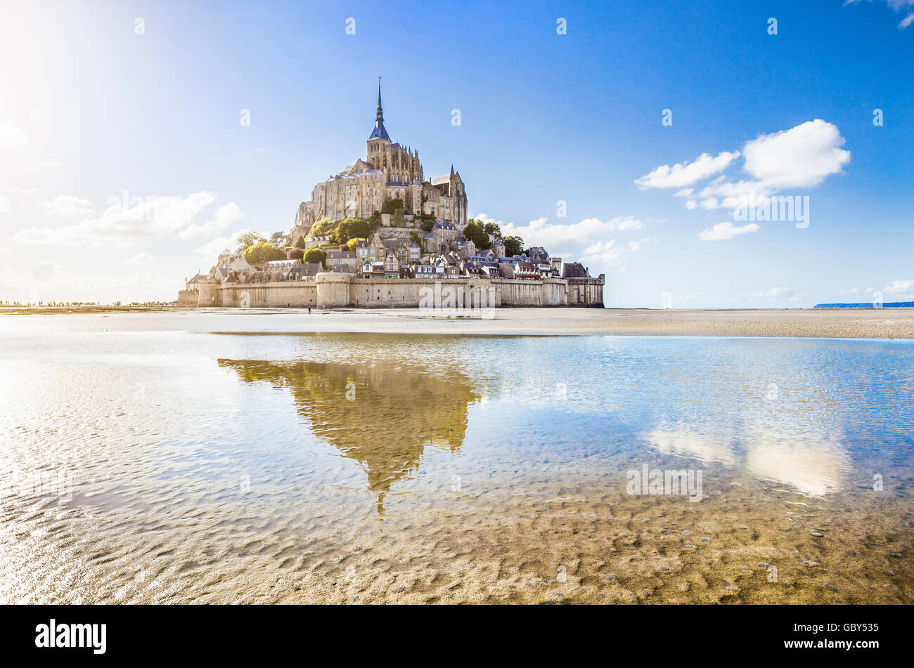 Visualizzazione classica del famoso Mont Saint Michel isola di marea in una giornata di sole con cielo blu e nuvole, Normandia, Francia settentrionale Foto Stock