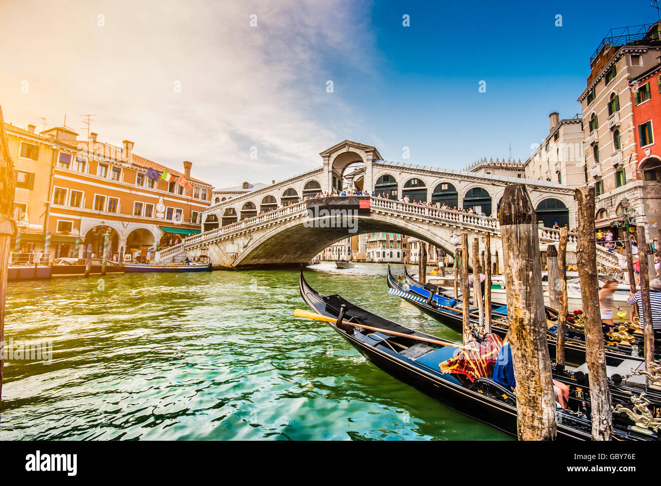 Visualizzazione classica delle tradizionali gondole sul famoso Canal Grande con il famoso Ponte di Rialto al tramonto a Venezia, Italia Foto Stock