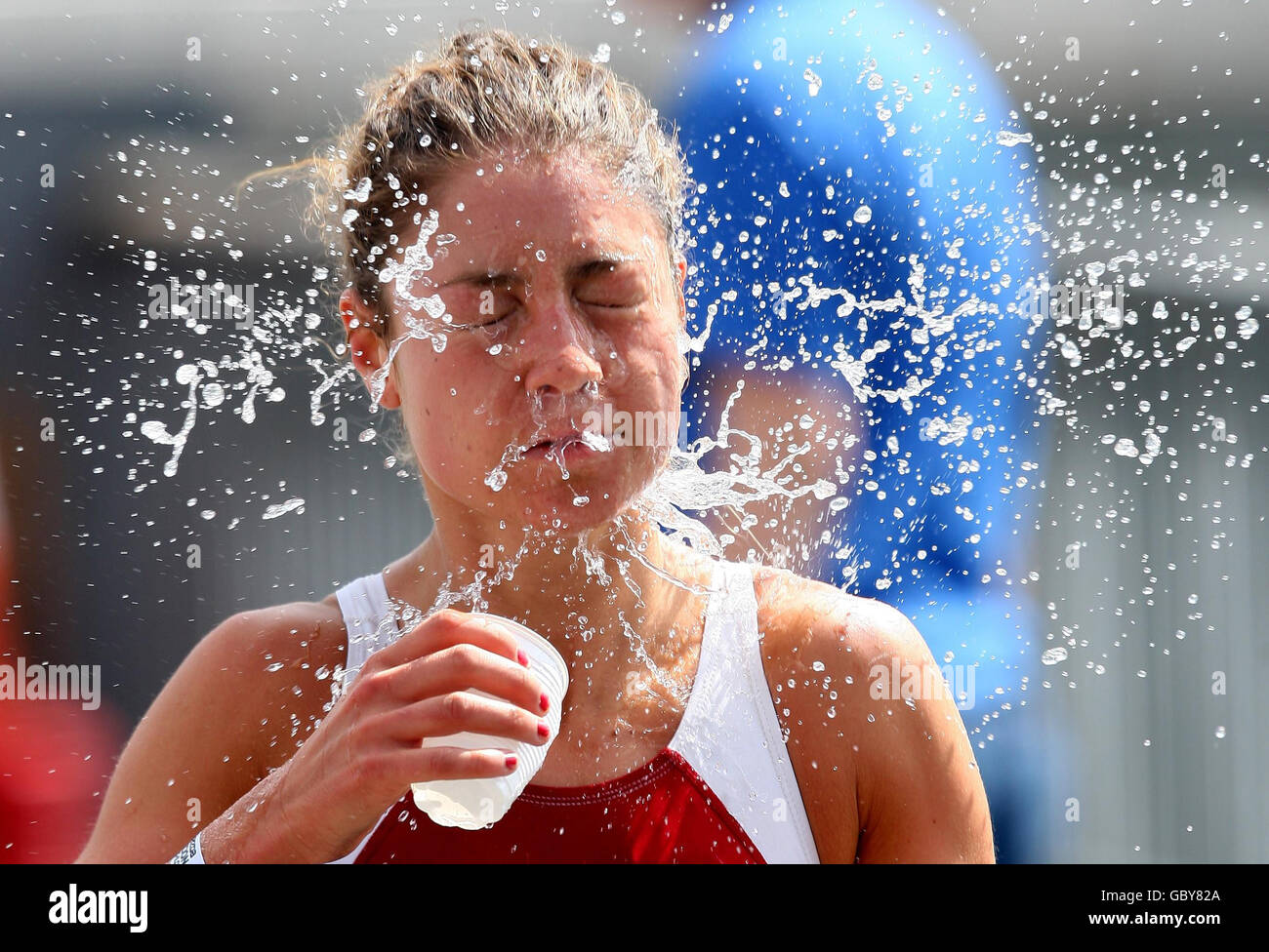 Sophie Coleman della Gran Bretagna lancia una tazza d'acqua sul suo volto mentre corre nella gara delle donne d'élite durante il Mazda London Triathlon, presso l'Excel Center di Docklands, nella zona est di Londra. Foto Stock