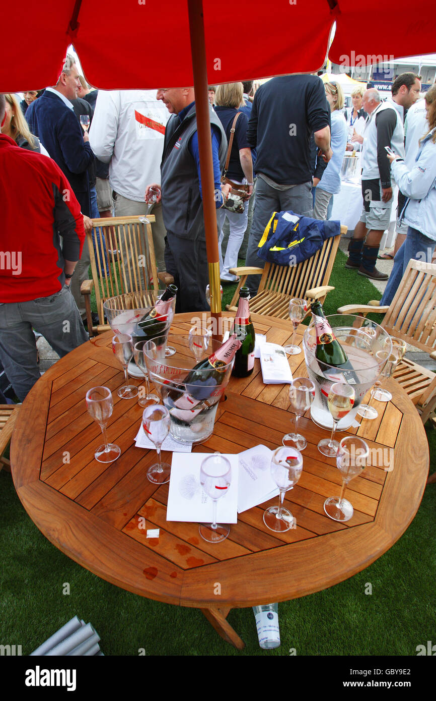 Un tavolo con bottiglie di champagne e bicchieri come lo champagne scorre al bar Champagne Mumm a Cowes Yacht Haven il terzo giorno della settimana dei Cowes, la regata velica famosa in tutto il mondo che si tiene ogni anno sul Solent, ma altrove gli incassi sono giù. Oggi gli organizzatori hanno smesso di addebitare agli spettatori l'ingresso alle feste serali a causa della mancanza di commercio. PREMERE ASSOCIAZIONE foto. Data immagine: Martedì 4 agosto 2009. La recessione è stata accusato di aver registrato un calo di circa il 15% rispetto agli anni precedenti. Circa 900 yacht si contenderanno negli otto giorni di gara durante il 183° anno dell'evento. Foto Foto Stock