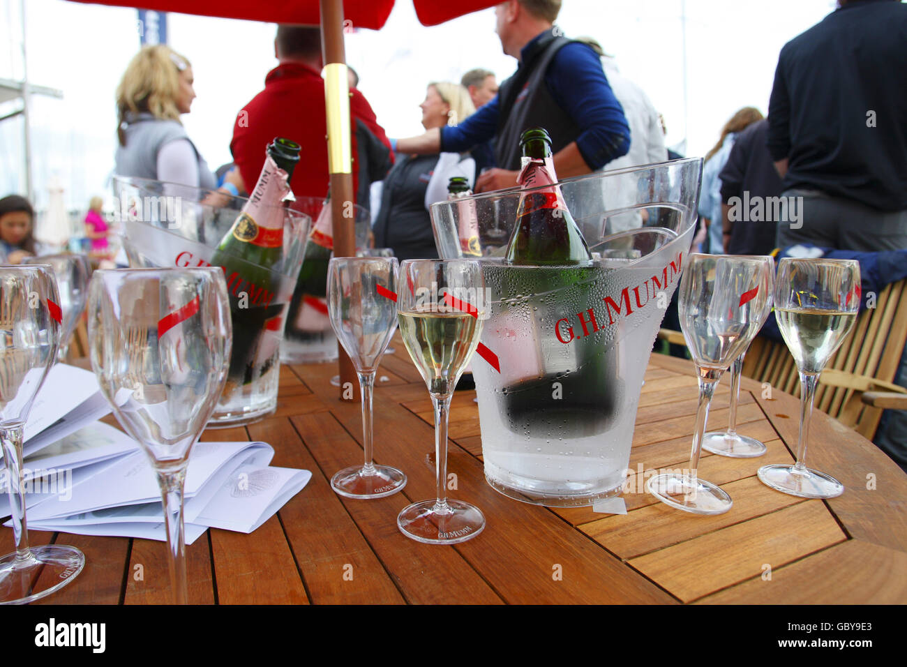 Un tavolo con bottiglie di champagne e bicchieri come lo champagne scorre  al bar Champagne Mumm a Cowes Yacht Haven il terzo giorno della settimana  dei Cowes, la regata velica famosa in