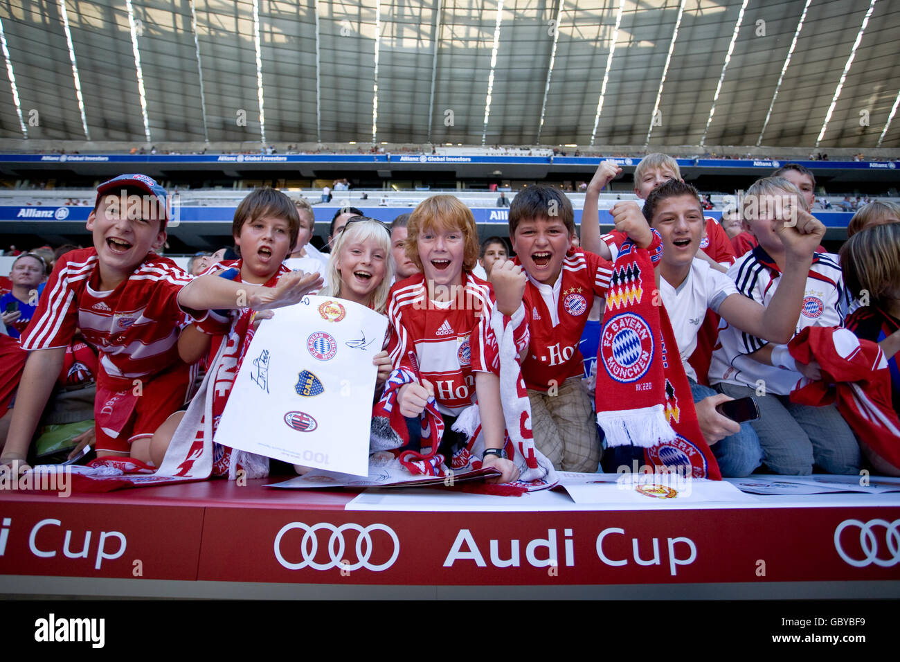 I giovani appassionati di Bayern Monaco si acclamano al loro fianco stand Foto Stock