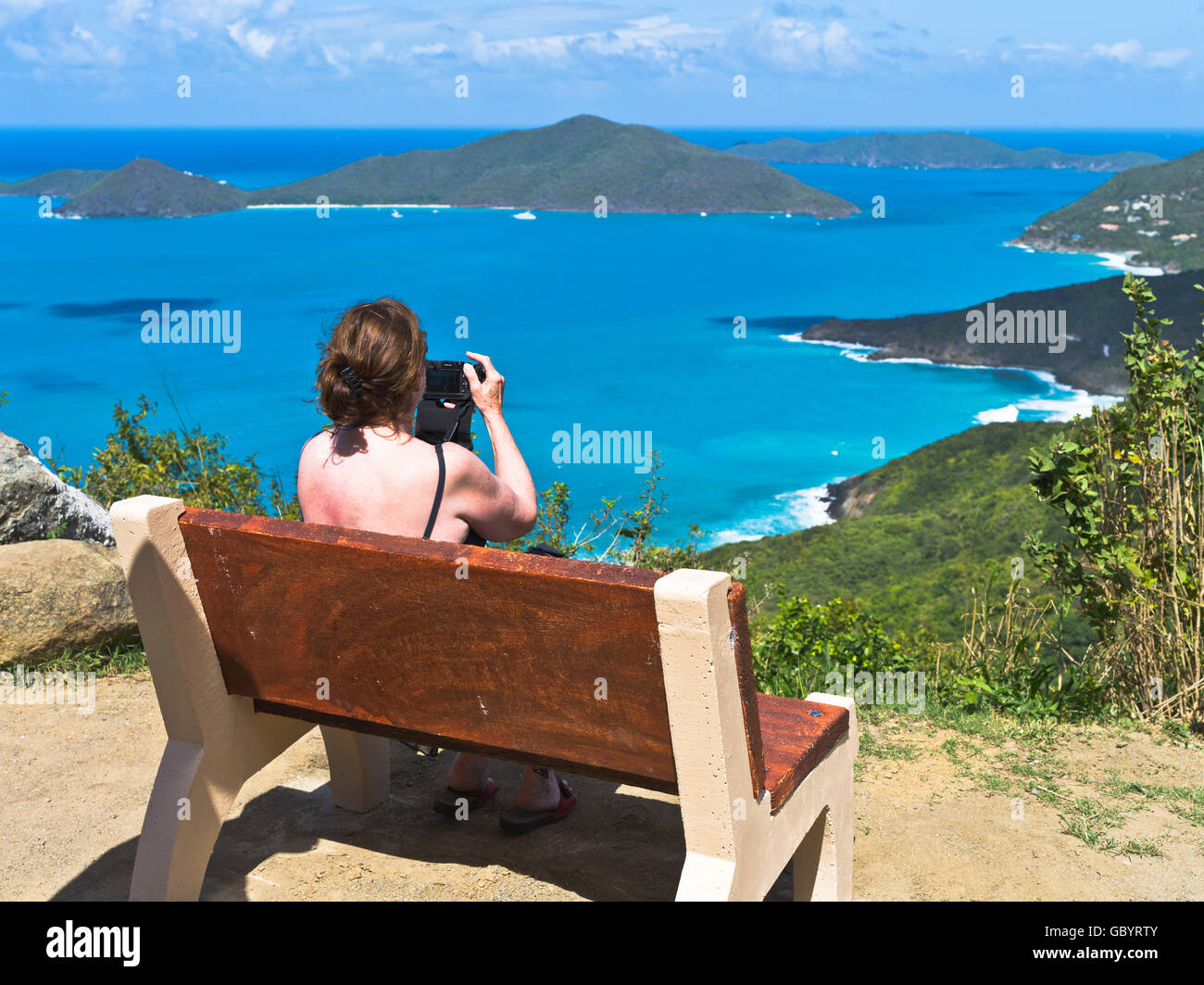 dh Ridge Road leeward Islands TORTOLA CARIBBEAN Woman turista scattare foto Vista di Josiahs Bay Island costa settentrionale panoramica Foto Stock