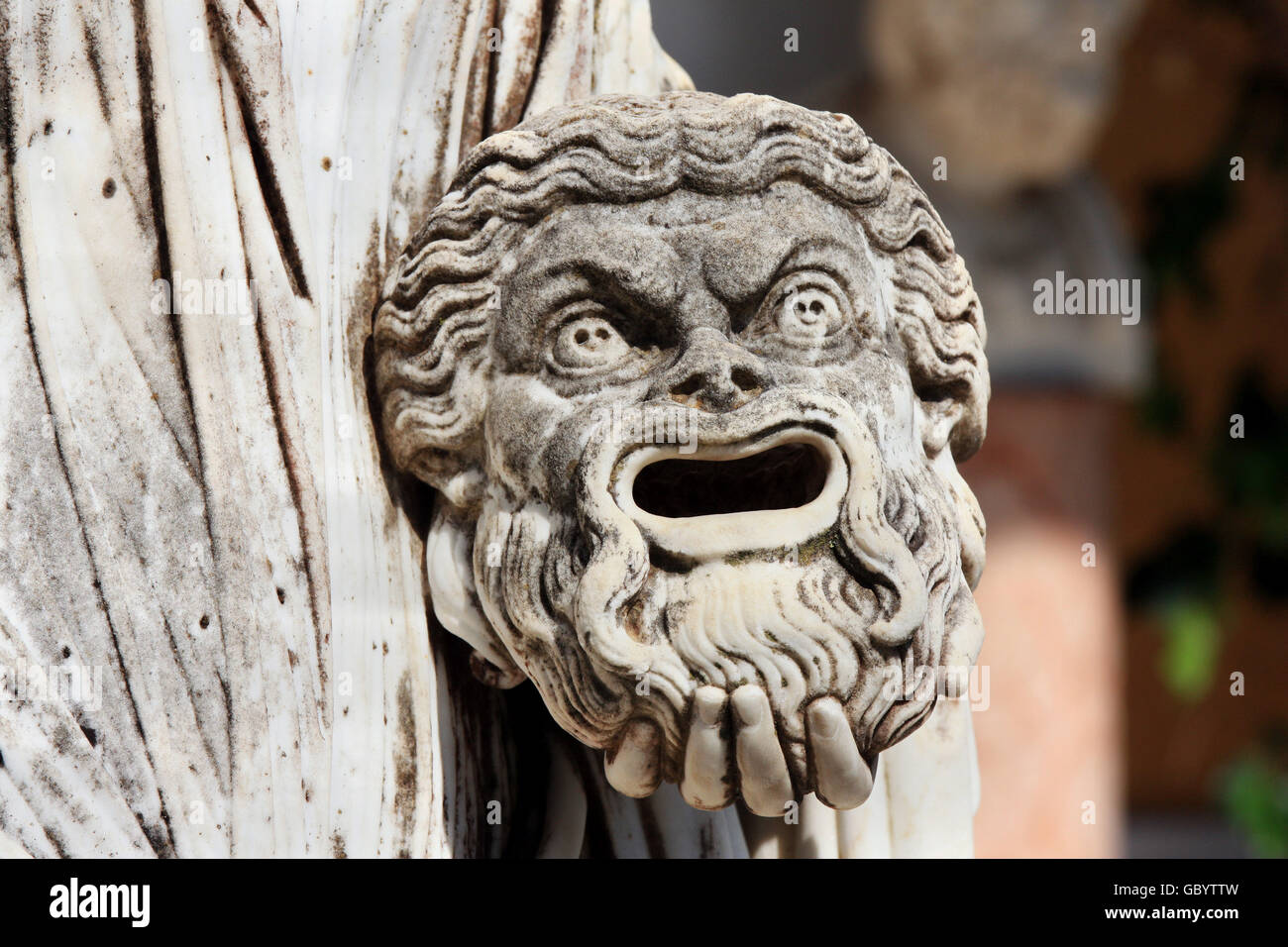 Una maschera tragica nella mano della statua di Melpomene : la musa della tragedia, sul balcone di Achillion Princess Sissy's Palace su gr Foto Stock