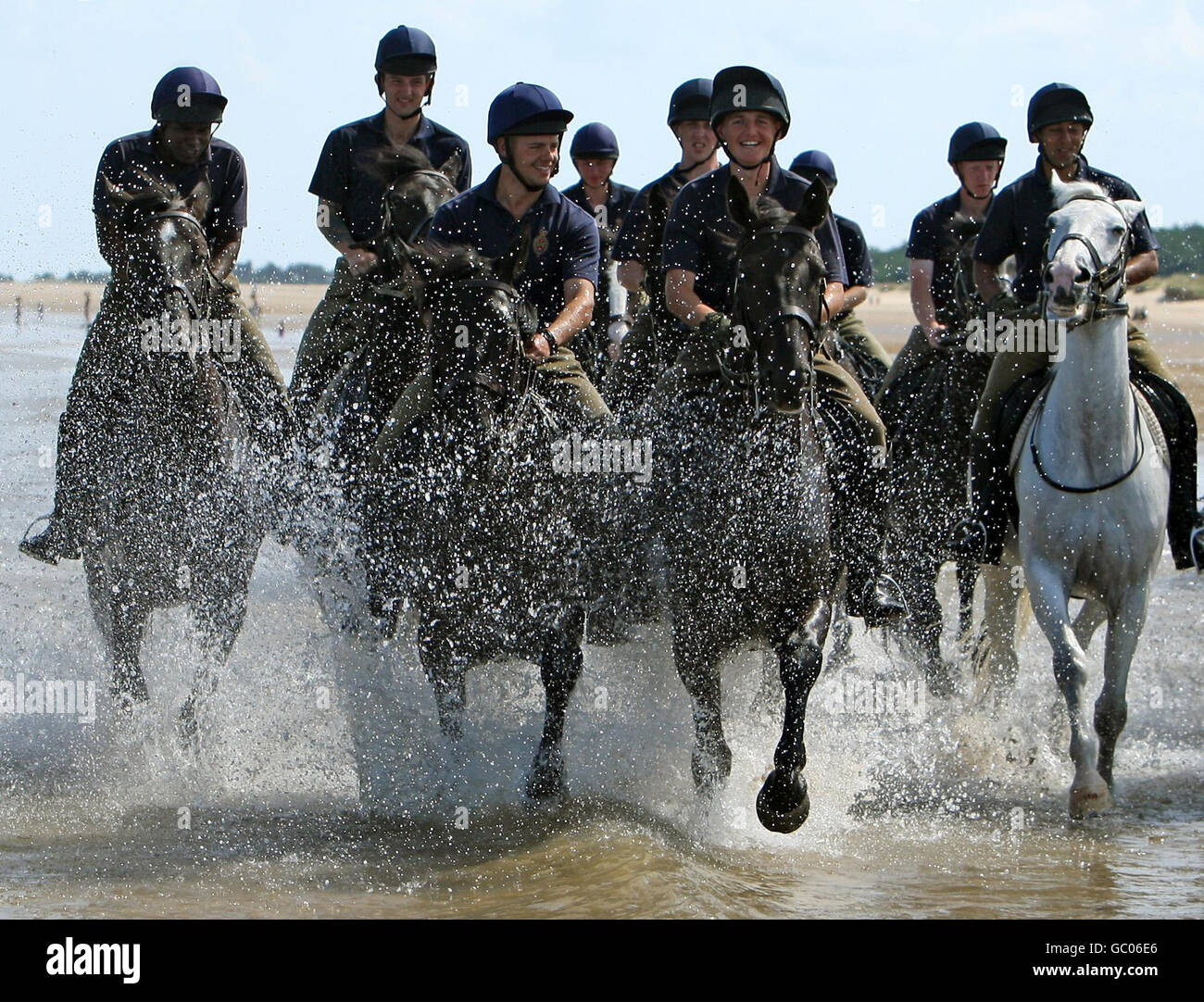 I soldati del Blues e dei reali della Casa Cavalleria Reggimento montato esercita i loro cavalli sulla spiaggia di Holkham, in Holkham, Norfolk durante il loro campo di addestramento estivo di tre settimane e una rottura dai doveri cerimoniali. Foto Stock