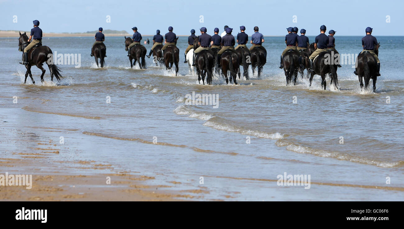 I soldati del Blues e dei reali della Casa Cavalleria Reggimento montato esercita i loro cavalli sulla spiaggia di Holkham, in Holkham, Norfolk durante il loro campo di addestramento estivo di tre settimane e una rottura dai doveri cerimoniali. Foto Stock