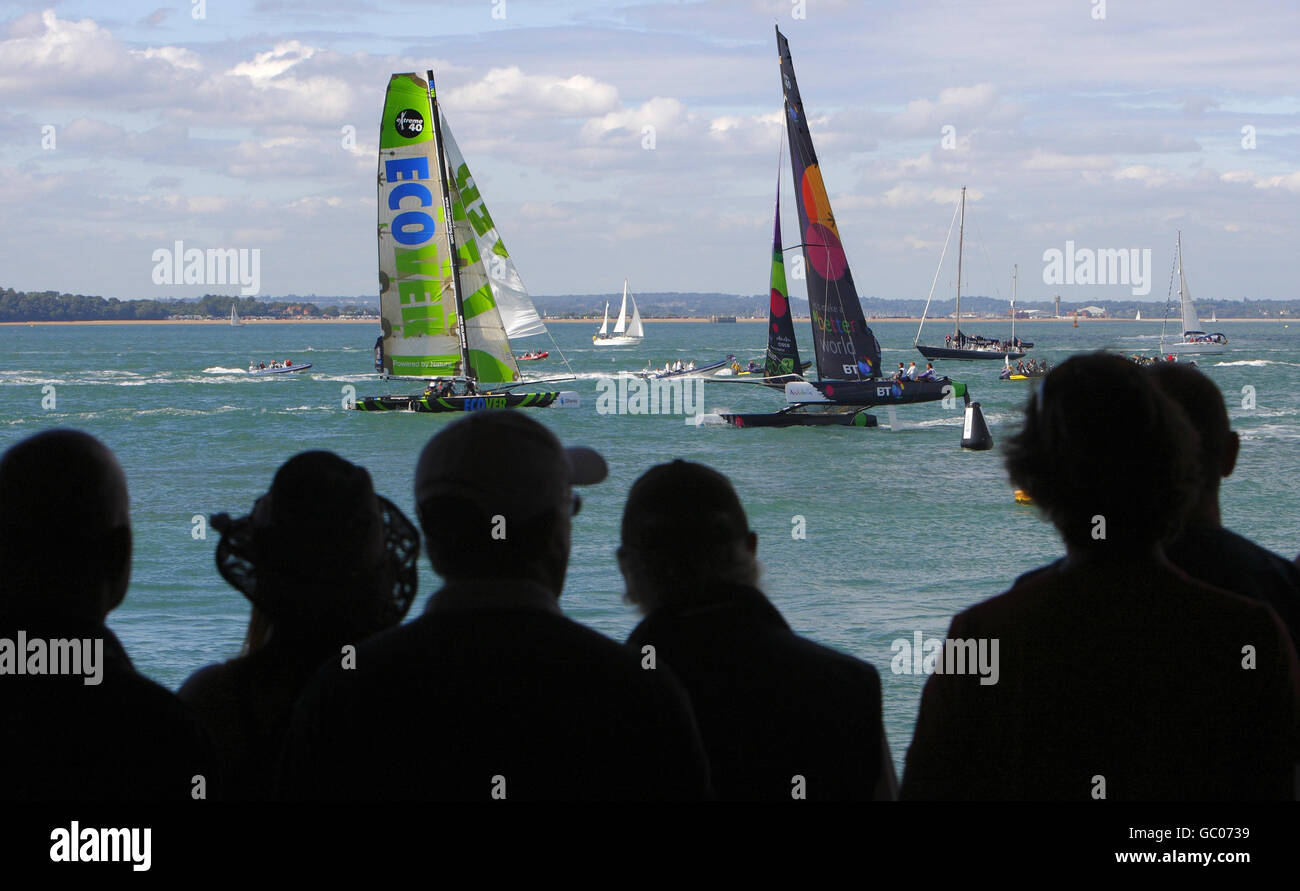 Gli spettatori guardano la flotta di catamarani Extreme 40 della iShares Cup che corre dal bar Shoreside il terzo giorno della Cowes Week, la regata velica famosa in tutto il mondo che si tiene ogni anno sul Solent. Foto Stock