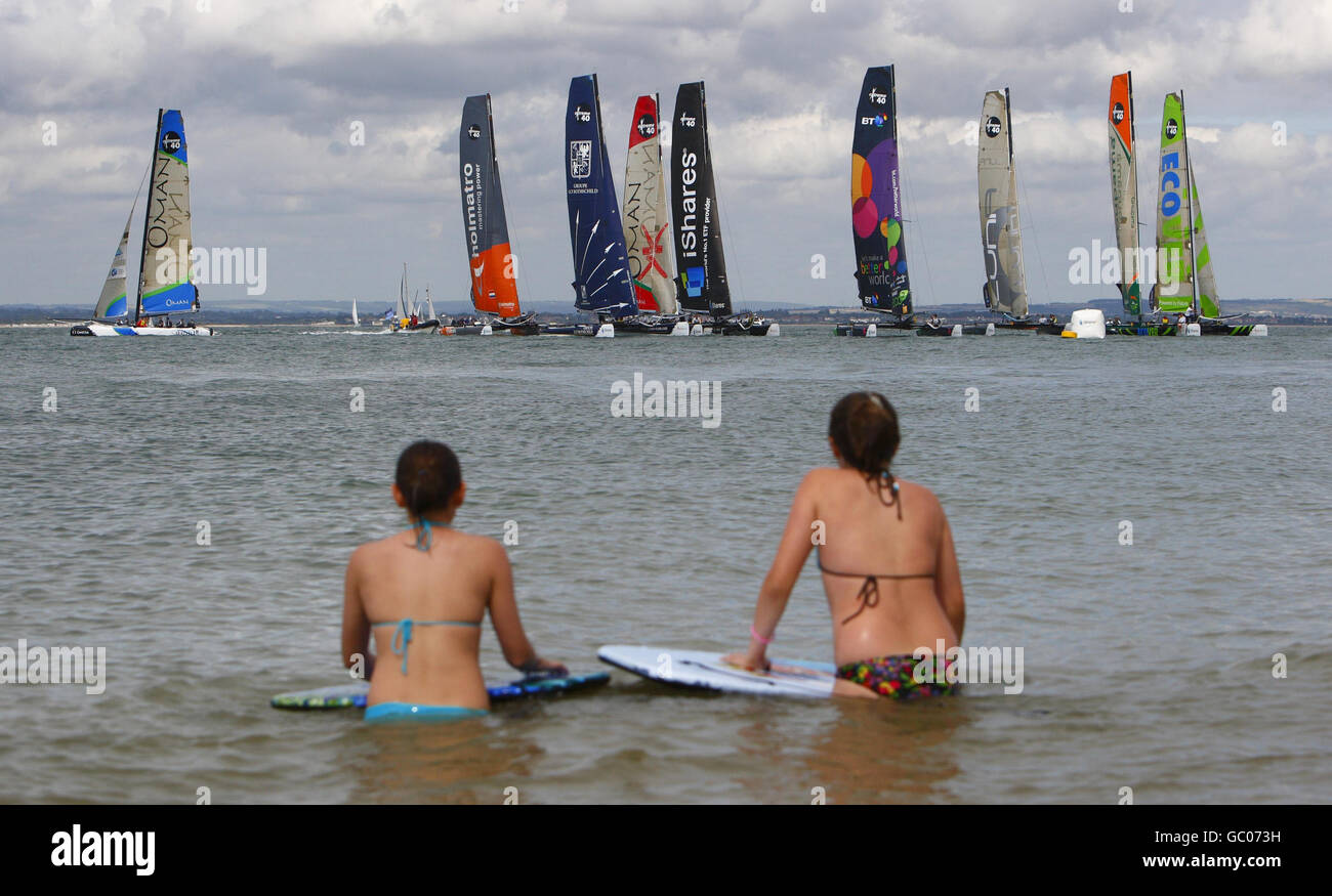 I body boarder guardano la flotta iShares Cup di catamarani Extreme 40 che corrono il terzo giorno della settimana di Cowes, la famosa regata velica che si tiene ogni anno sul Solent. Foto Stock