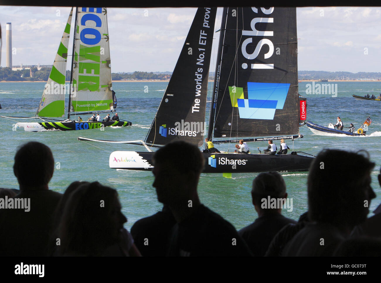 Gli spettatori guardano la flotta di catamarani Extreme 40 della iShares Cup che corre dal bar Shoreside il terzo giorno della Cowes Week, la regata velica famosa in tutto il mondo che si tiene ogni anno sul Solent. Foto Stock