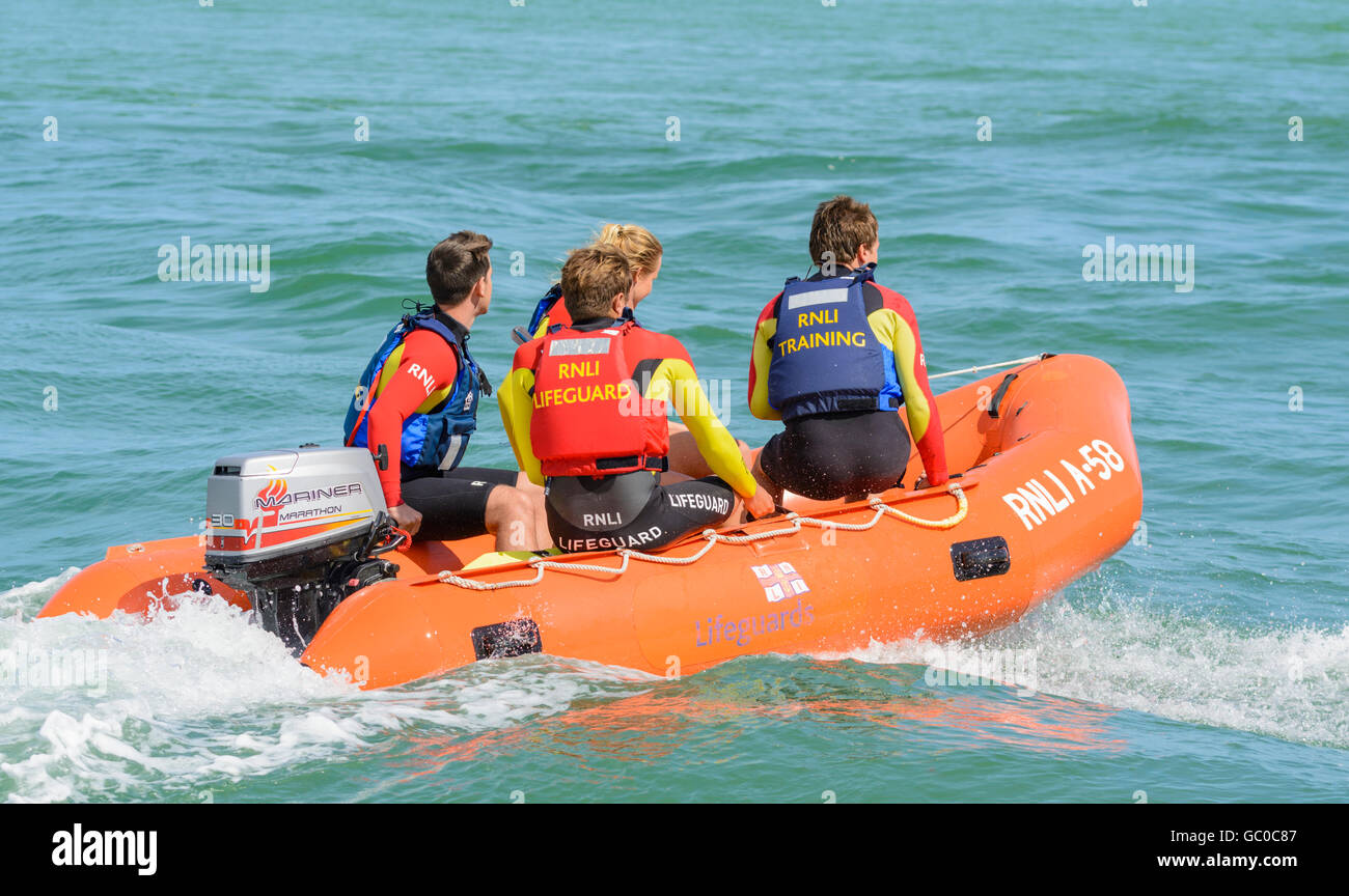RNLI Arancia A-58 addestramento di bagnino gonfiabile in barca di salvataggio sul mare vicino a Littlehampton Beach, West Sussex, Inghilterra, Regno Unito Foto Stock