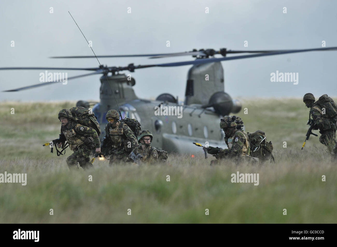 I soldati del 1° Battaglione reale gallese si trasferiscono al loro obiettivo con un elicottero Chinook sullo sfondo che li ha fatti cadere nella zona di combattimento di addestramento a Brecon mentre prendono parte ad un esercizio di addestramento pre-dispiegamento in anticipo della loro missione in Afghanistan all'inizio di ottobre. Foto Stock